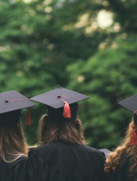 An image depicting college graduates wearing a cap and gown.